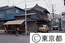 佃に残る明治の住宅の前を歩く高齢者