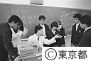 化学の授業のあと、質問ぜめに会う先生、国際高校にて