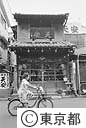 古い佃煮の店の前で自転車に乗る子供