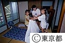 民宿で布団の上げ下ろしをする親子（東京国際交流の船）